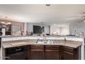 Kitchen featuring a large sink and backsplash with a view of the open floorplan of the living space at 40345 W Molly Ln, Maricopa, AZ 85138