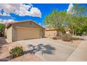 Charming single-story home with a two-car garage, long driveway, and xeriscaped front yard at 44976 W Miramar Rd, Maricopa, AZ 85139