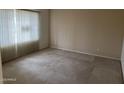 Neutral bedroom featuring a large window with blinds and neutral carpeting at 4801 E Sheena Dr, Scottsdale, AZ 85254