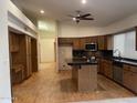 Eat-in kitchen features wood cabinets, an island with seating, a ceiling fan, and wood flooring at 4801 E Sheena Dr, Scottsdale, AZ 85254