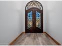 Interior view of the detailed iron and glass front doors, with a view of the tiled flooring at 7482 S Mccormick Way, Queen Creek, AZ 85142