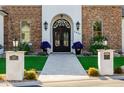 Close-up of the front entrance with ornate iron double doors, stone pillars, and a paved walkway at 7482 S Mccormick Way, Queen Creek, AZ 85142