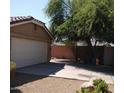 A single-Gathering home featuring a two-car garage and desert landscaping at 7771 N 58Th Ln, Glendale, AZ 85301