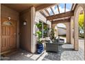 Warm, covered entryway with tiled flooring, comfortable seating, and charming arched supports at 858 W Knowles Cir, Mesa, AZ 85210