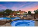 Backyard pool and spa area with lounge chairs and desert landscaping at 9435 E Hobart Cir, Mesa, AZ 85207