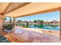 Covered patio overlooking serene waterfront view with decorative tile flooring, great for outdoor living at 11023 W Chino Dr, Peoria, AZ 85373
