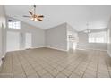 Spacious living room featuring neutral paint, tile floors, ceiling fan and plentiful natural light from clerestory windows at 11044 N 75Th Dr, Peoria, AZ 85345