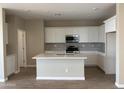 Modern kitchen with white cabinets, stainless steel appliances, and a center island at 18180 W Larkspur Dr, Goodyear, AZ 85338