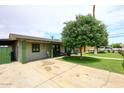 Charming single-story home with well-kept lawn, a wide driveway, and lush green trees at 2916 N 48Th Ave, Phoenix, AZ 85031