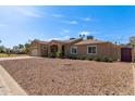 A well-maintained single-story home with a low-water landscape, covered entry, and side yard access at 3034 E Turney Ave, Phoenix, AZ 85016