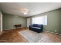Open-concept living room with light green walls, tan tile flooring, and a ceiling fan at 322 N Williams St, Mesa, AZ 85203