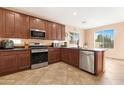 Modern kitchen featuring stainless steel appliances, dark cabinetry, and tile flooring at 44348 W Windrose Dr, Maricopa, AZ 85138