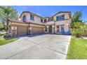 This two-story home features a spacious three car driveway and manicured lawn with a basketball hoop at 4609 E Ironhorse Rd, Gilbert, AZ 85297