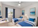 Bright bedroom featuring two twin beds, desk, and large window with stylish blue curtains at 4939 E Paradise Dr, Scottsdale, AZ 85254