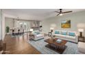 Open-concept living room with hardwood floors, neutral paint, modern furnishings, and seamless flow to dining area at 4939 E Paradise Dr, Scottsdale, AZ 85254