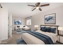 Spacious main bedroom with seating area, stylish decor, ceiling fan, and abundant natural light at 4939 E Paradise Dr, Scottsdale, AZ 85254