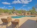 Beautiful backyard swimming pool with lounging chairs, and desert landscape views at 5141 E Rancho Tierra Dr, Cave Creek, AZ 85331