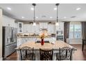 Bright kitchen featuring a large center island, white cabinetry, stainless steel appliances, and granite countertops at 683 W Honey Locust Ave, Queen Creek, AZ 85140