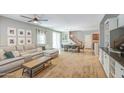 Spacious living room with ceiling fan, carpet flooring, and large sofa at 935 S Deerfield Ln, Gilbert, AZ 85296