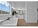 Elegant bathroom with freestanding tub, large window, wood-look tile flooring, and a separate glass shower at 1111 E Peach Tree Dr, Chandler, AZ 85249