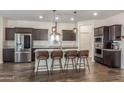 Modern kitchen boasts stainless steel appliances, a kitchen island with seating, and pendant lighting at 17296 W Molly Ln, Surprise, AZ 85387