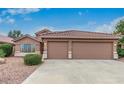 Charming single-story home with a three-car garage, desert landscaping, and a tile roof at 17827 N 51St Way, Scottsdale, AZ 85254