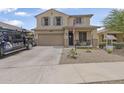 Two-story home with desert landscaping, a covered front porch, and a two-car garage, American flag at 17935 W Louise Dr, Surprise, AZ 85387