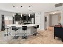 Modern kitchen featuring a large island with seating, pendant lighting, stainless steel appliances, and tile backsplash at 25947 W Oraibi Dr, Buckeye, AZ 85396