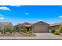 Attractive single-story home showcasing a tile roof, desert landscaping, and a paved driveway at 27057 W Tonopah Dr, Buckeye, AZ 85396