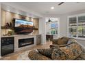 Comfortable living room with a fireplace, built-in shelving, and a view to an office space at 27057 W Tonopah Dr, Buckeye, AZ 85396