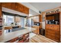 Kitchen with wooden cabinets, brick features, stainless steel refrigerator, and laminate flooring at 4323 W Rose Ln, Glendale, AZ 85301