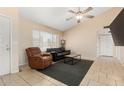 Cozy living room featuring a ceiling fan, neutral walls, and tile flooring at 6926 W Comet Ave, Peoria, AZ 85345