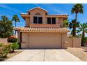 Two-story home featuring a tile roof, attached garage, and low-maintenance landscaping at 7702 W Piute Ave, Glendale, AZ 85308