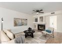 Bright living room with a fireplace, modern decor, and comfortable seating on light colored flooring at 7702 W Piute Ave, Glendale, AZ 85308