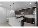 This is a gourmet kitchen with an island, stainless steel appliances, and dark cabinets with pendant lights at 11408 S 50Th Ln, Laveen, AZ 85339