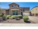 Charming two-story home with desert landscaping, a brick driveway, and a two-car garage, bathed in bright sunlight at 11875 W Lone Tree Trl, Peoria, AZ 85383
