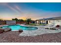 Beautiful backyard featuring a custom-designed pool, ample space for lounging, and lovely sunset views at 15019 W Banff Ln, Surprise, AZ 85379