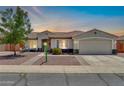Inviting home with a well-lit exterior, a cozy front patio, and a convenient two-car garage at 15019 W Banff Ln, Surprise, AZ 85379