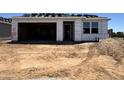 New home construction with an attached garage and materials staged on lot at 15793 W Beryl Ave, Waddell, AZ 85355