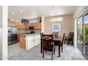 Open-concept kitchen with stainless steel appliances and dining area with natural light at 16222 W Silver Falls Dr, Surprise, AZ 85374