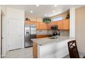 Well-lit kitchen featuring granite countertops, stainless steel appliances, and light wood cabinetry at 16222 W Silver Falls Dr, Surprise, AZ 85374