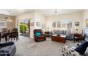 Comfortable living room with plush seating, neutral tones, and natural light filtering through plantation shutters at 16222 W Silver Falls Dr, Surprise, AZ 85374