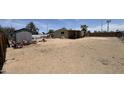Wide shot of dirt lot backyard with miscellaneous lawn and garden equipment, as well as wood fencing at 20626 N 35Th Ave, Glendale, AZ 85308