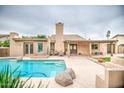 Inviting backyard featuring a sparkling pool, covered patio, and well-maintained landscaping for outdoor enjoyment at 2329 W Keating Ave, Mesa, AZ 85202