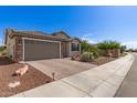 Charming single-story home featuring a brick driveway and desert landscaping at 26753 W Zachary Dr, Buckeye, AZ 85396