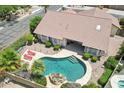 Aerial view of a backyard featuring a private pool, lounge chairs, lush landscaping, and a tiled roof at 4428 E Yawepe St, Phoenix, AZ 85044