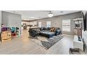 Spacious living room featuring a gray couch and wood floors at 45173 W Sandhill Rd, Maricopa, AZ 85139