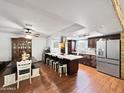Spacious kitchen with a large island, stainless steel appliances, wooden cabinetry, and hardwood floors at 4639 W Keim Dr, Glendale, AZ 85301