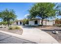 Desert-landscaped single-story home with a winding driveway and a blue sky backdrop at 6334 E Albany St, Mesa, AZ 85205