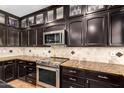 Modern kitchen with stainless steel appliances, granite countertops, and custom cabinetry at 10130 E San Salvador Dr, Scottsdale, AZ 85258